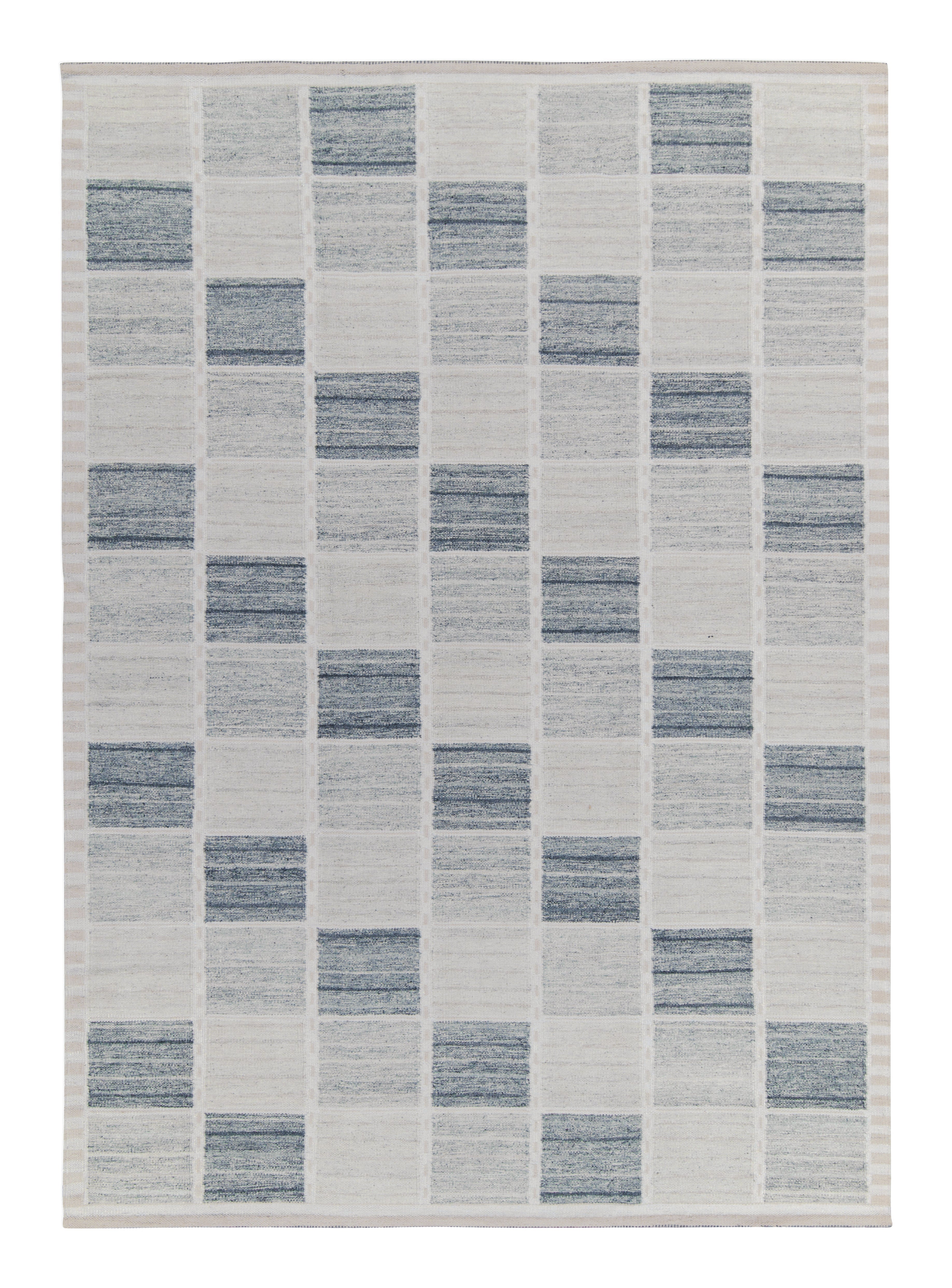 Rug with a geometric pattern of blue and gray squares on a white background